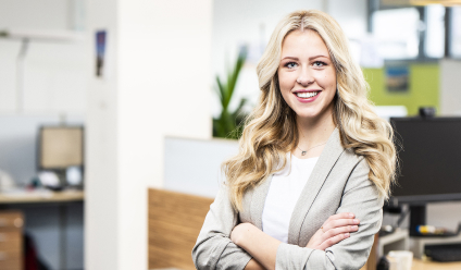 Junge blonde Frau lächelnd in einem Bürogebäude