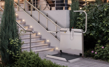 Plattformlift für Rollstuhlfahrer an einer beleuchteten Außentreppe