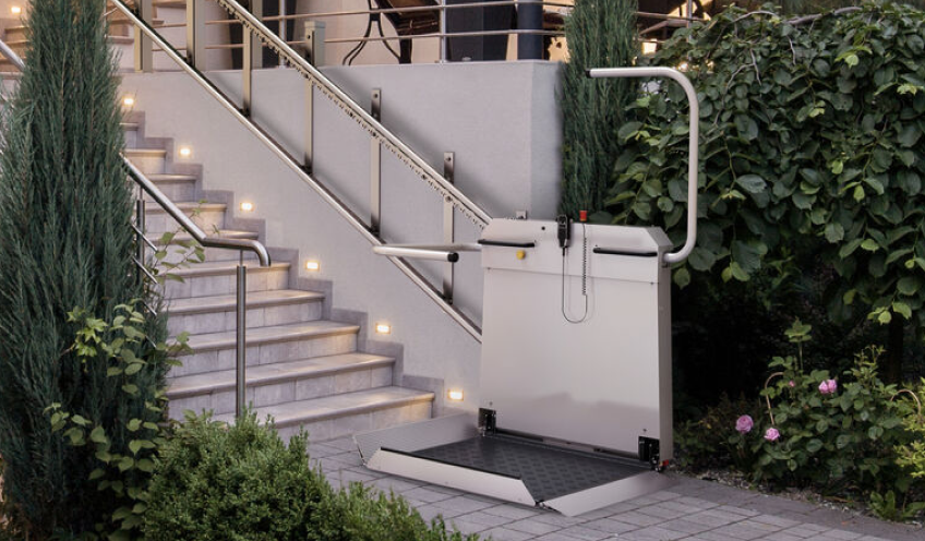 Plattformlift für Rollstuhlfahrer von sani-trans am Ende einer beleuchteten Außentreppe