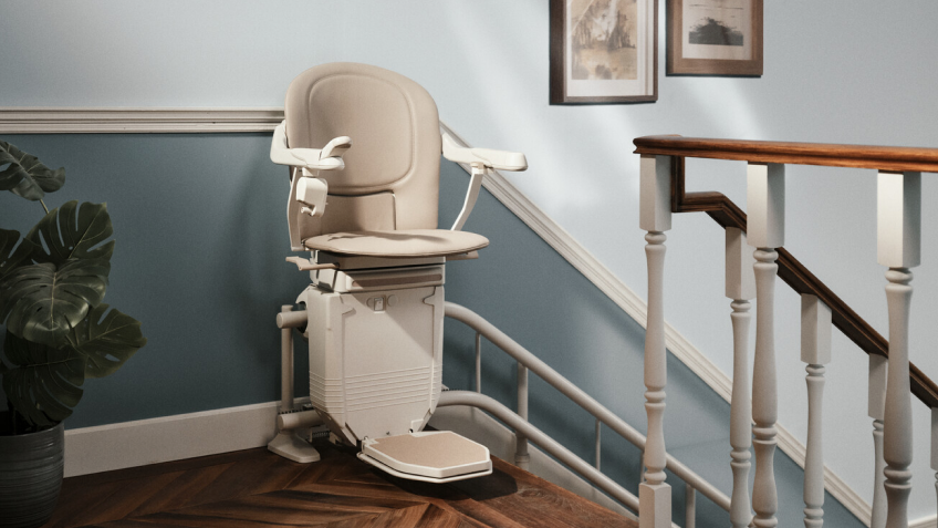 markenteaser-lifta.png Beiger Treppenlift von Lifta am oberen Ende einer Treppe vor hellblauer Wand