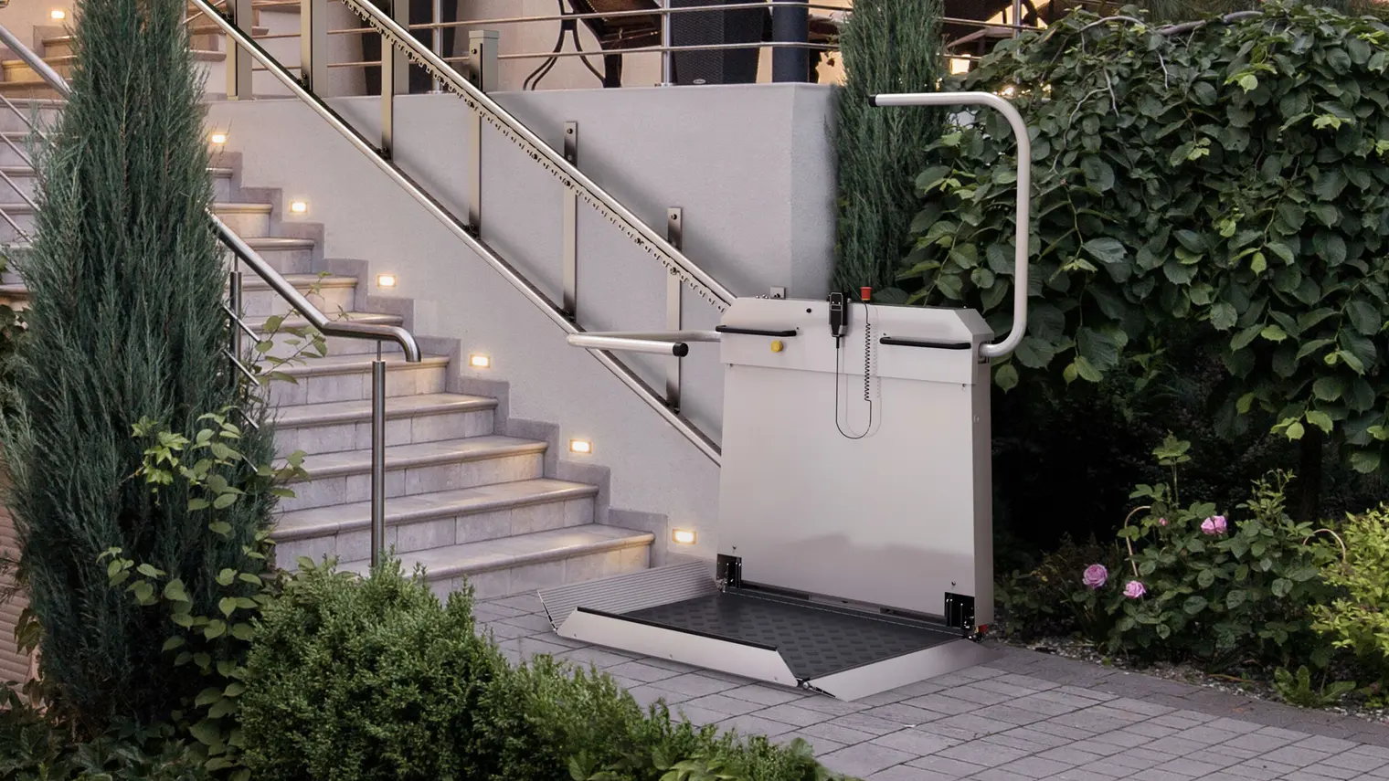 Plattformlift für Rollstuhlfahrer von sani-trans am Ende einer beleuchteten Außentreppe