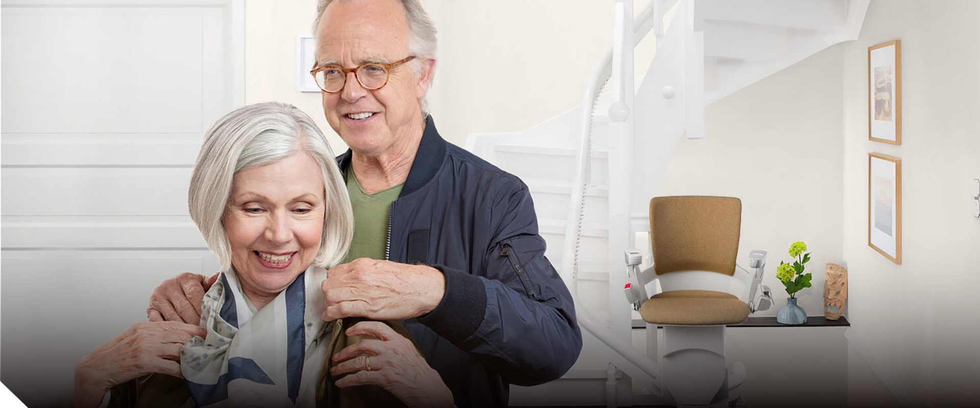 header-start.png Lächelndes älteres Paar vor einem Treppenlift